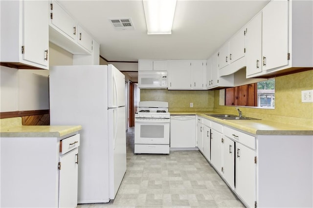 kitchen with tasteful backsplash, white cabinetry, sink, light tile patterned flooring, and white appliances