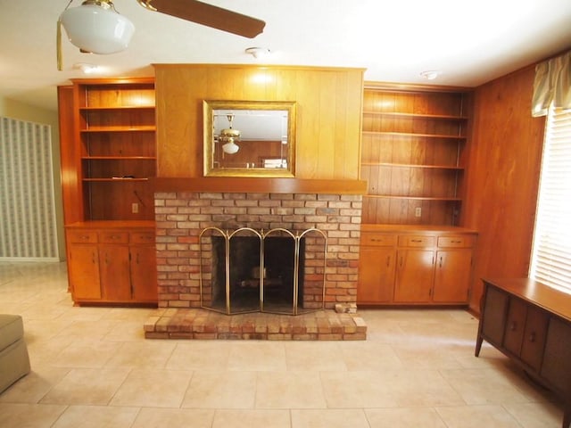 tiled living room with built in shelves, wood walls, and a fireplace