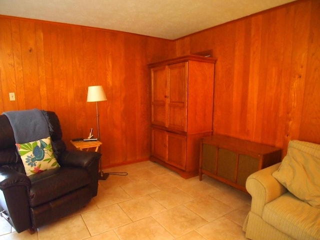 sitting room featuring light tile patterned floors and wood walls