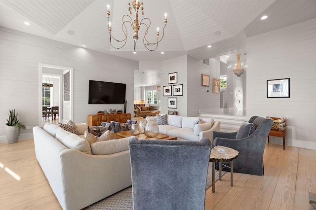 living room with light wood-type flooring and a chandelier