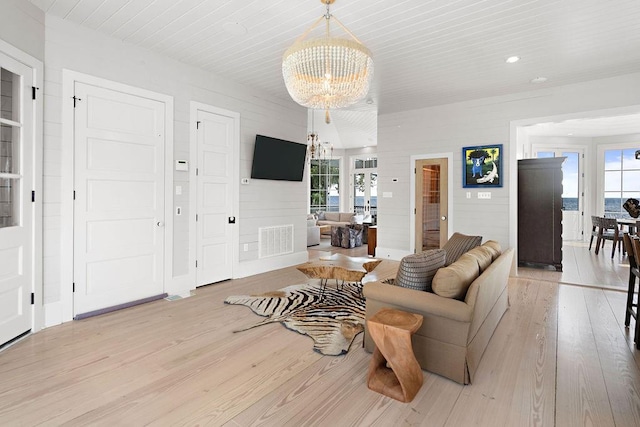 living room with an inviting chandelier and light wood-type flooring