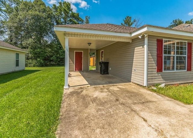 view of front of property with a carport and a front lawn