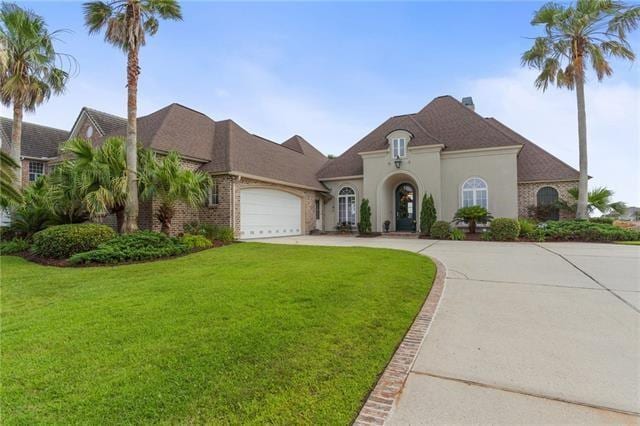 view of front of home with concrete driveway, a garage, brick siding, and a front lawn