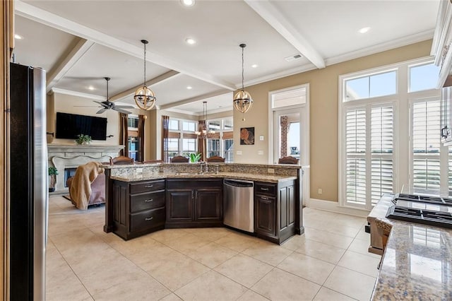 kitchen featuring pendant lighting, ceiling fan with notable chandelier, crown molding, light stone countertops, and appliances with stainless steel finishes