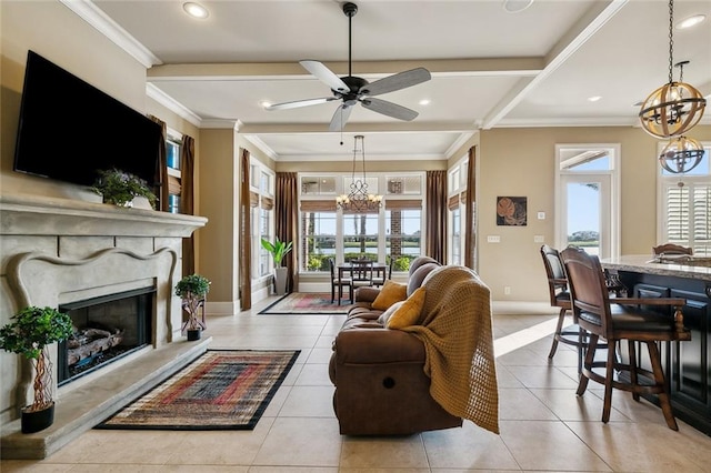 living room featuring ceiling fan with notable chandelier, light tile patterned floors, a high end fireplace, and ornamental molding