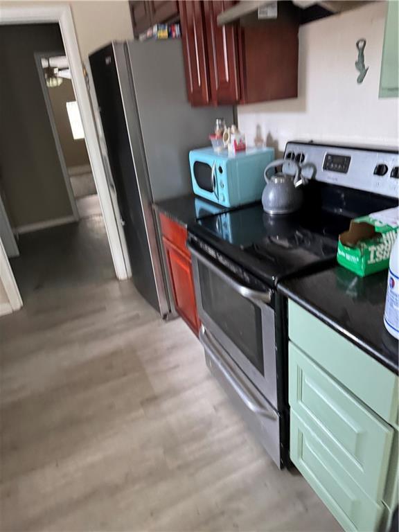 kitchen featuring stainless steel electric stove and light wood-type flooring