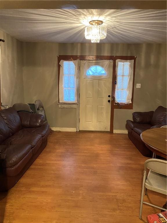 8836 Forshey St, New Orleans, LA 70118 - living room featuring baseboards, light wood finished floors, and a chandelier