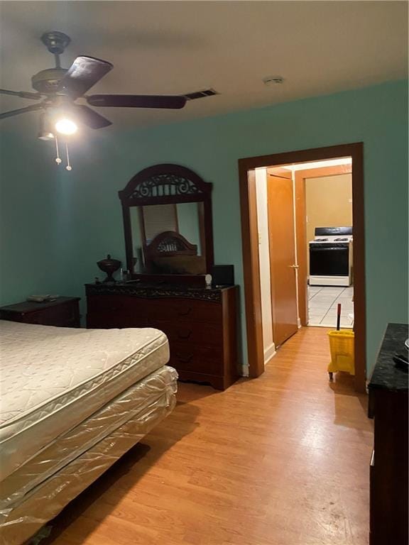 bedroom featuring light hardwood / wood-style floors, ceiling fan, and a closet