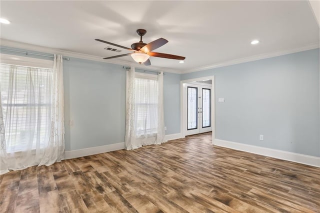 unfurnished room with ornamental molding, visible vents, baseboards, and wood finished floors