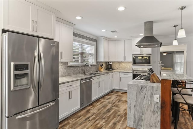 kitchen featuring decorative light fixtures, island exhaust hood, appliances with stainless steel finishes, white cabinets, and light stone countertops