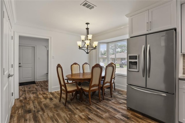 dining room featuring dark wood-style flooring, crown molding, visible vents, a chandelier, and baseboards