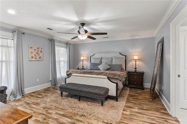 bedroom featuring visible vents, ornamental molding, and wood finished floors