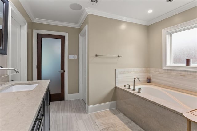 bathroom with baseboards, visible vents, ornamental molding, a garden tub, and vanity