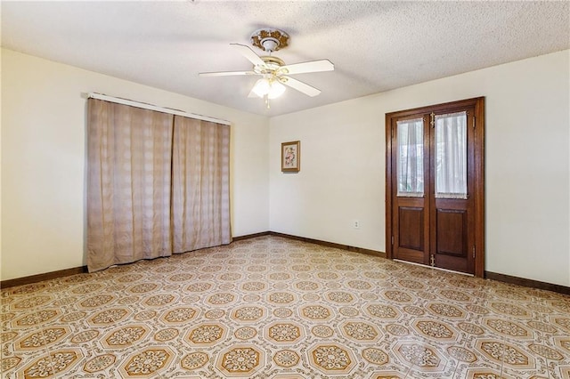 empty room featuring ceiling fan, a textured ceiling, and light tile patterned floors