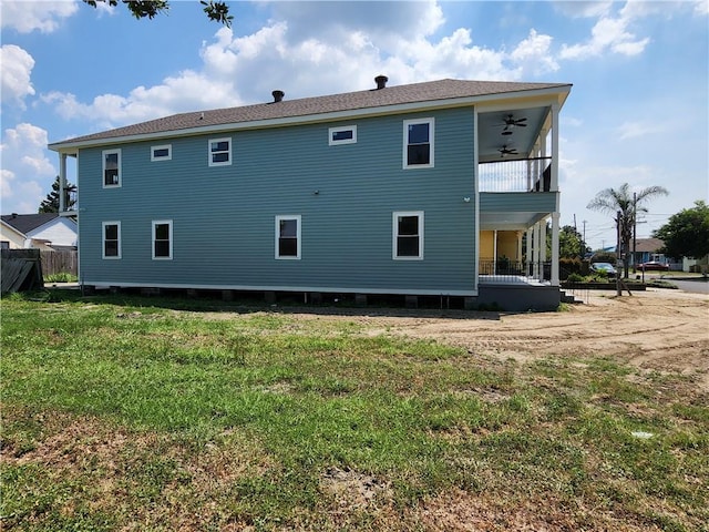 back of house featuring ceiling fan and a yard