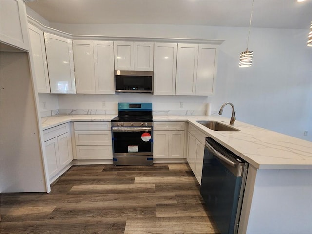 kitchen with sink, dark hardwood / wood-style flooring, appliances with stainless steel finishes, white cabinetry, and kitchen peninsula