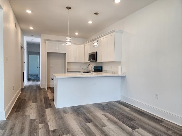 kitchen featuring white cabinetry, dark wood-type flooring, and kitchen peninsula