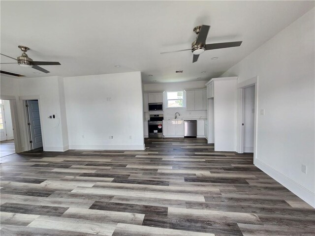 unfurnished living room featuring ceiling fan, hardwood / wood-style flooring, and sink