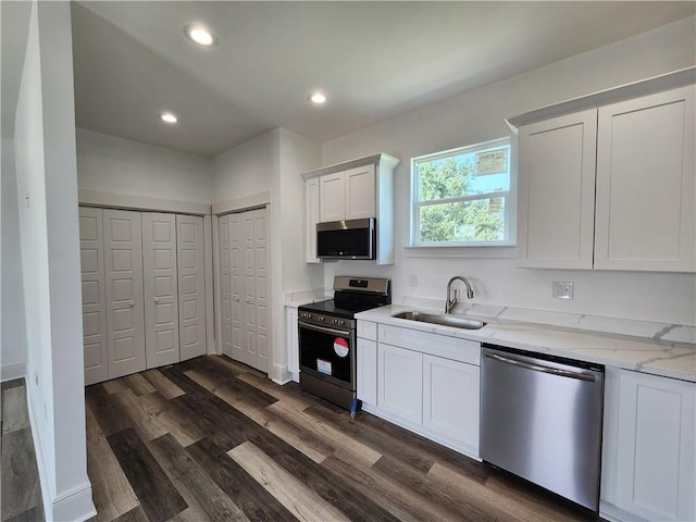 kitchen featuring sink, light stone countertops, dark hardwood / wood-style floors, white cabinetry, and stainless steel appliances