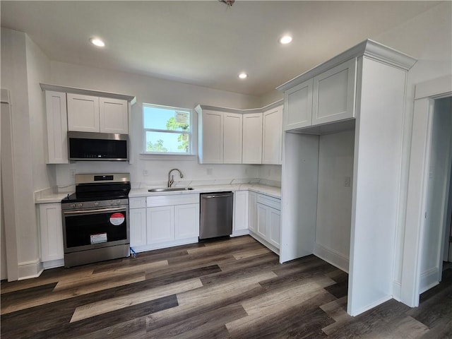 kitchen featuring sink, stainless steel appliances, white cabinetry, and dark hardwood / wood-style flooring