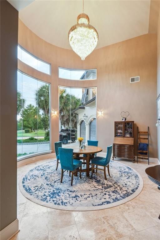 dining space featuring a chandelier and a high ceiling