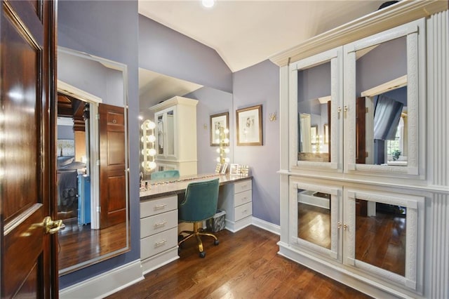 office area with lofted ceiling, built in desk, and dark hardwood / wood-style floors