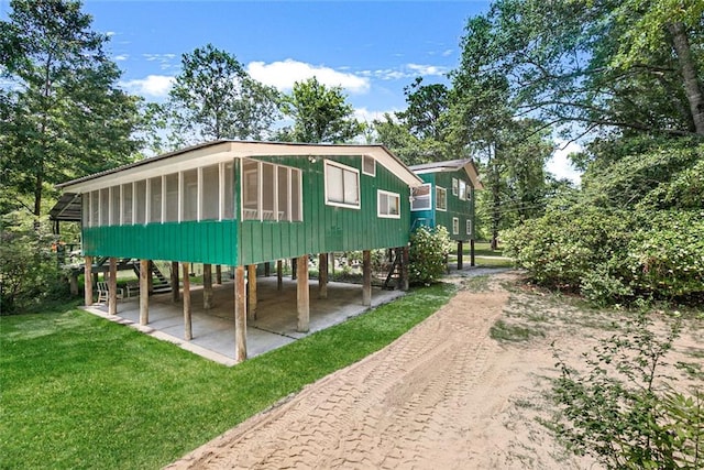 rear view of house featuring a lawn and a carport