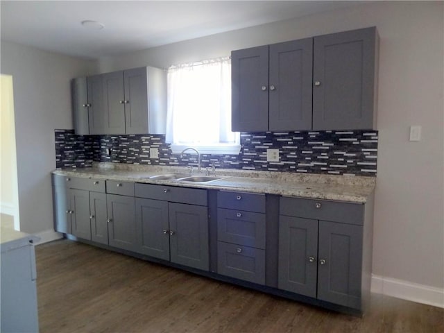 kitchen featuring dark wood-style floors, gray cabinets, light countertops, and a sink