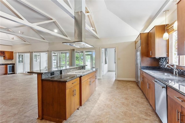 kitchen featuring appliances with stainless steel finishes, dark stone countertops, lofted ceiling with beams, decorative light fixtures, and sink