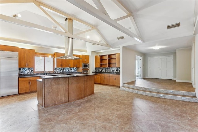 kitchen featuring tasteful backsplash, a kitchen island, built in appliances, range hood, and vaulted ceiling with beams