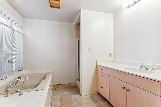 bathroom featuring a wealth of natural light, independent shower and bath, and vanity