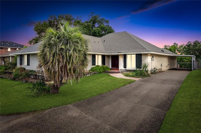 ranch-style house featuring a front lawn and a carport