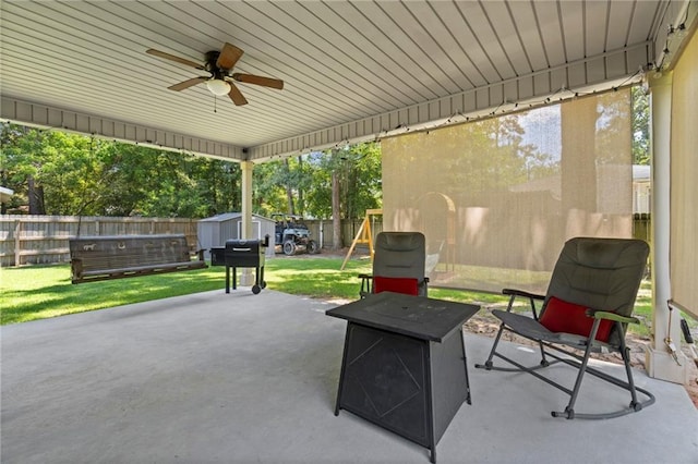 view of patio with a fenced backyard, a storage unit, an outdoor structure, and a ceiling fan