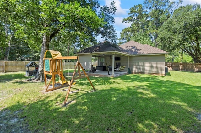 back of house featuring a playground, roof with shingles, a lawn, a fenced backyard, and a patio