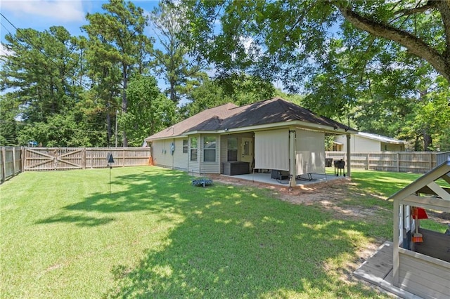 back of house with a yard, a patio, a fenced backyard, and a gate