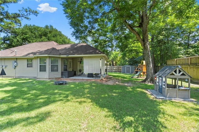 back of property featuring an outbuilding, a lawn, a patio, a fenced backyard, and a shed