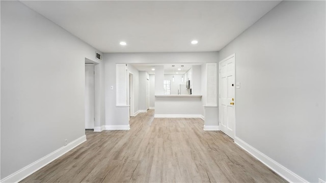 empty room featuring light wood-type flooring, baseboards, visible vents, and recessed lighting