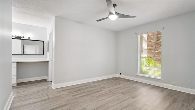 spare room with baseboards, a healthy amount of sunlight, and light wood finished floors