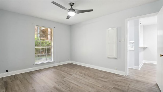 unfurnished room with light wood-style floors, ceiling fan, and baseboards