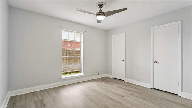 unfurnished bedroom featuring light wood-style flooring, baseboards, and a ceiling fan