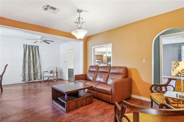 living room featuring ceiling fan and dark hardwood / wood-style flooring