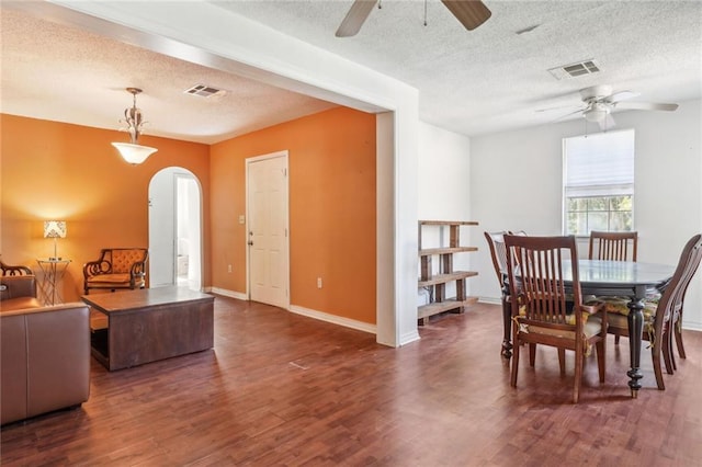 dining space with a textured ceiling, ceiling fan, and dark hardwood / wood-style floors