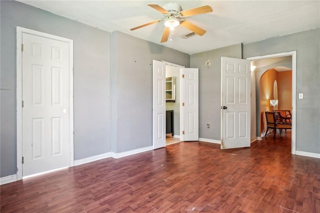 unfurnished bedroom featuring ceiling fan and dark hardwood / wood-style flooring