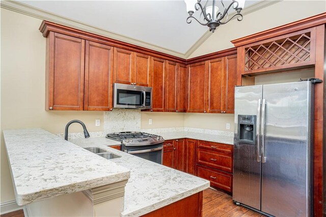 kitchen featuring stainless steel appliances, light hardwood / wood-style flooring, a chandelier, sink, and lofted ceiling