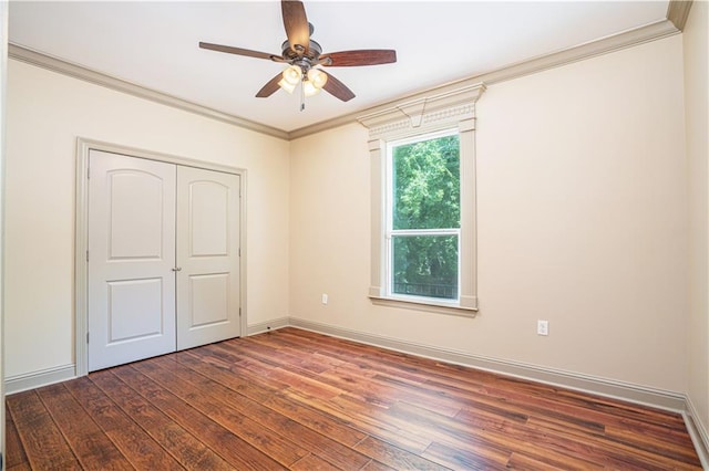 unfurnished bedroom featuring ceiling fan, a closet, crown molding, and dark hardwood / wood-style floors