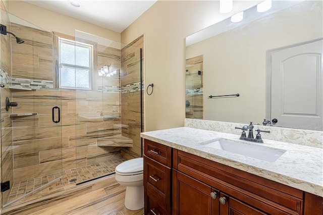 bathroom with toilet, vanity, and walk in shower