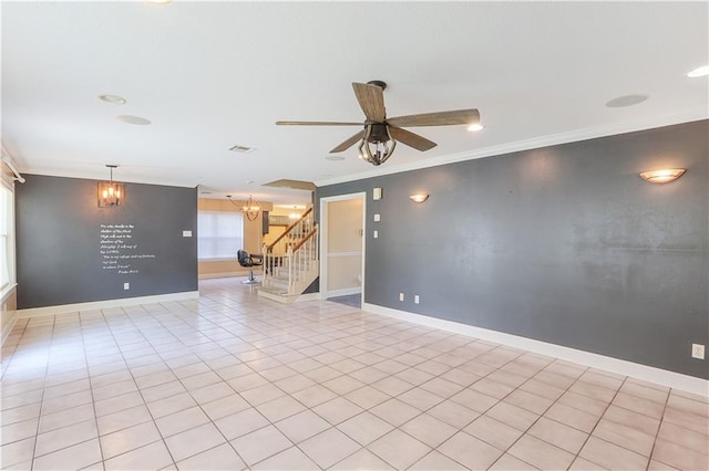 tiled empty room with ceiling fan with notable chandelier and ornamental molding