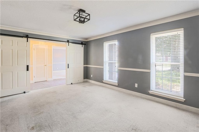 unfurnished bedroom with light carpet, a barn door, and ornamental molding