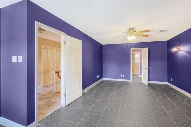 tiled spare room with ceiling fan