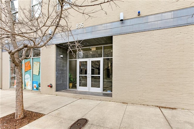 entrance to property featuring french doors and brick siding